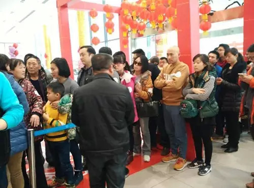 排隊領(lǐng)年貨，一家老小齊上陣。