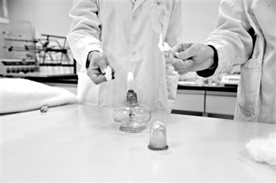 實驗人員操作的燃燒檢測法中，真蠶絲離開火焰就熄滅(左)。