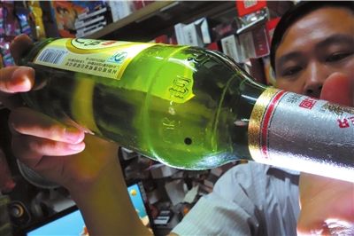 這瓶未開(kāi)封的燕京啤酒內(nèi)有一顆黑色懸浮物。京華時(shí)報(bào)記者 徐曉帆 攝