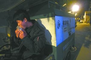 快遞哥抽空吃兩口東西。記者 李剛 攝