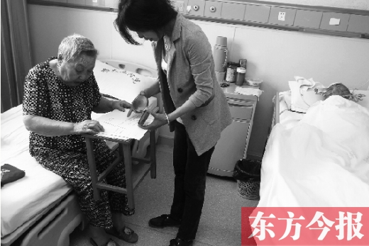 昨日，鄭大五附院二號(hào)樓住院部，馬老太寫下委托書，并簽字摁指印委托女兒代理為昏迷老伴解鎖取錢