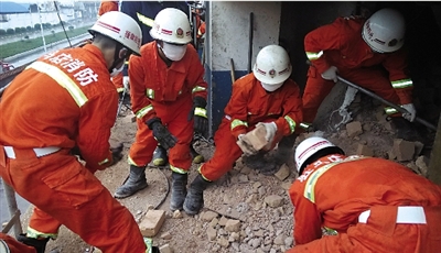 消防人員在清理熔鹽爐倒塌的廢墟。