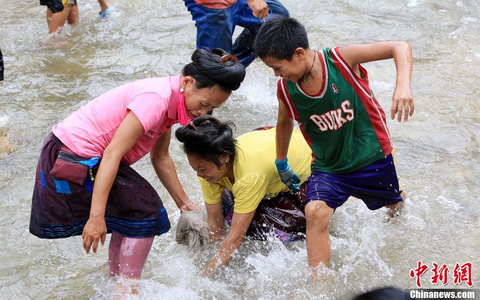 7月9日，村民在小河里摸魚搶魚。譚凱興 攝