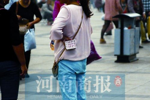 火車站廣場(chǎng)，一女子拿著寫(xiě)有不同房型價(jià)位的卡片在拉客，不少市民抱怨，受過(guò)此類“騷擾”