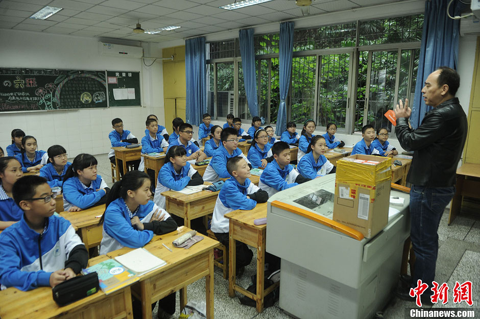 圖為老師正在向同學們講解用非智能手機對他們的好處。