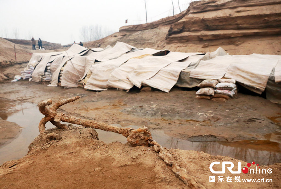 2014年1月6日，河南洛陽古沉船發(fā)掘現(xiàn)場(chǎng)，古沉船鐵錨從見天日，靜靜地躺在古船旁。
