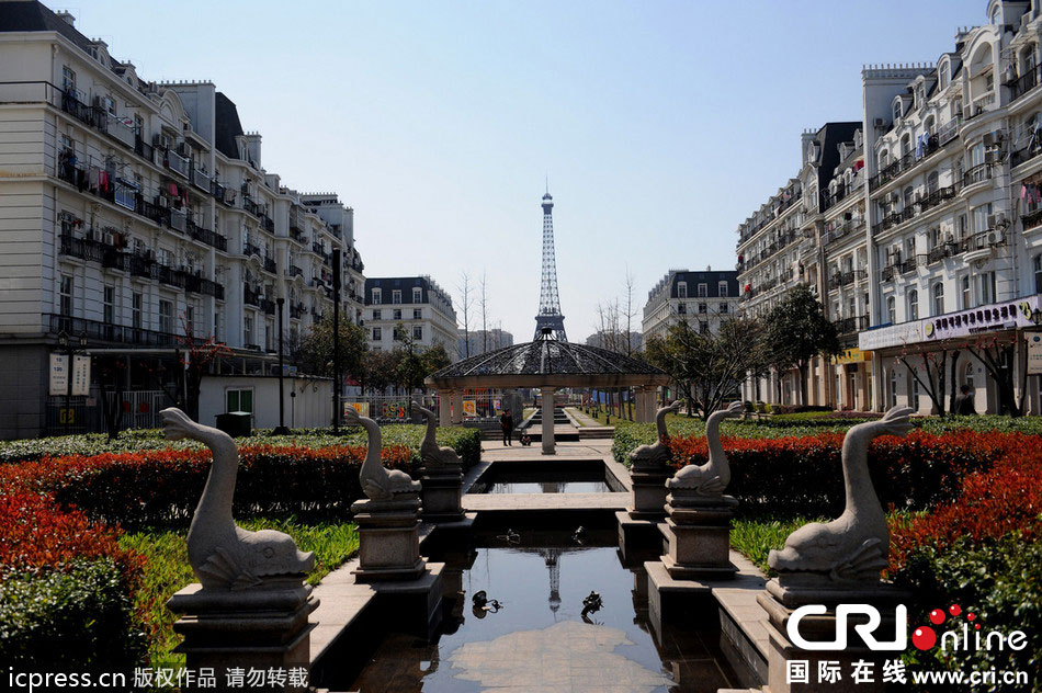 　2014年3月21日，杭州天都城，農民在山寨埃菲爾鐵塔下耕作。圖片來源：東方IC