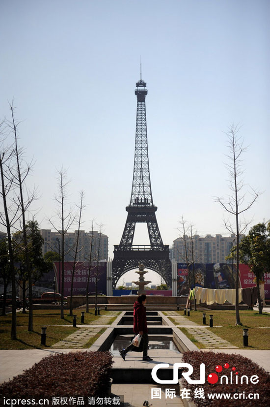 　2014年3月21日，杭州天都城，農民在山寨埃菲爾鐵塔下耕作。圖片來源：東方IC