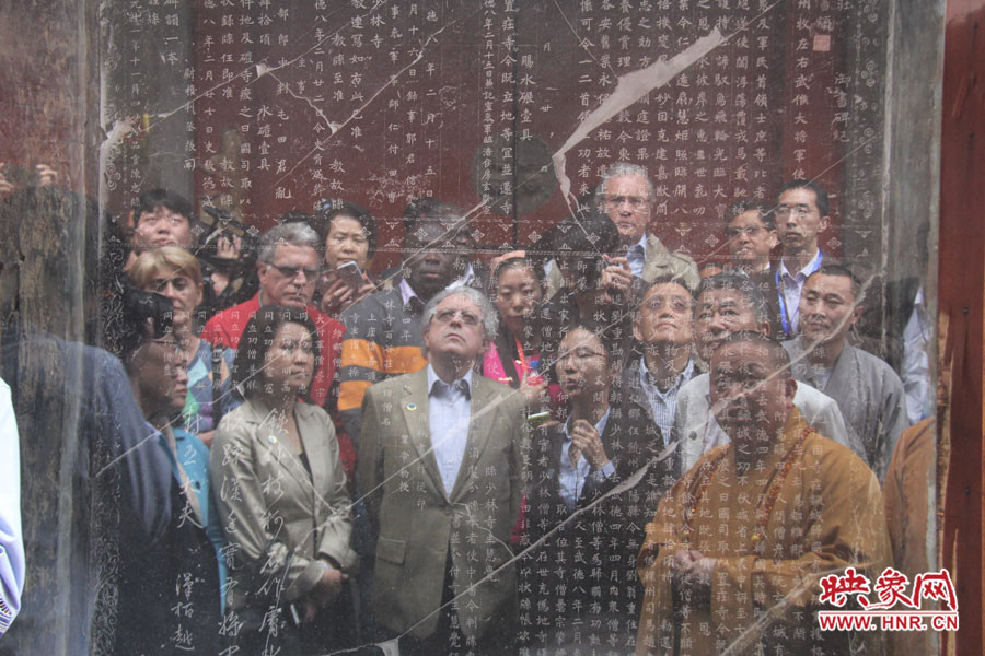 在一塊石碑前，少林寺方丈正在講解