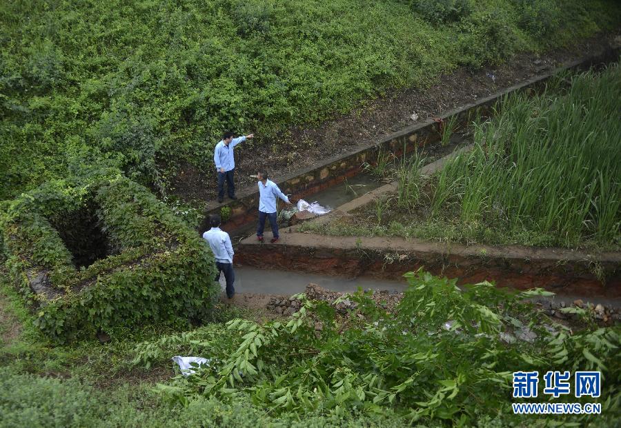 5月18日，工作人員在槽罐車泄漏現(xiàn)場(chǎng)附近的水渠邊查看情況。