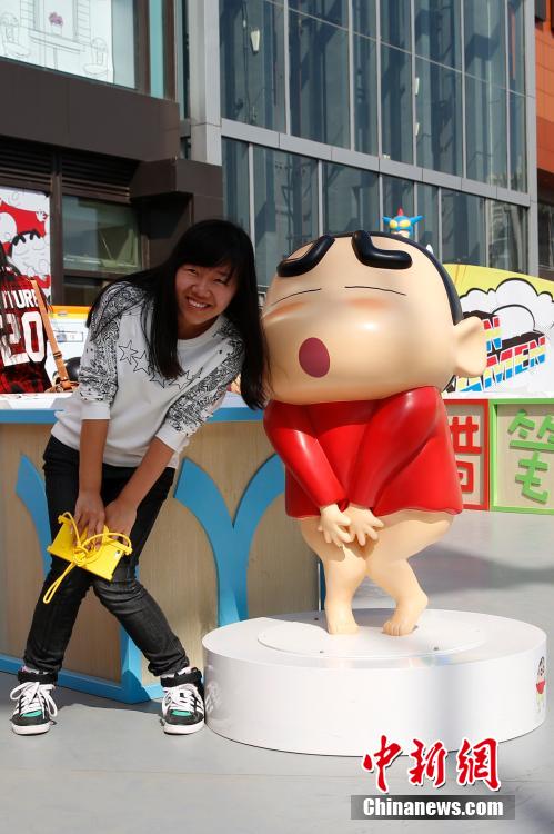4月22日，游客與蠟筆小新合影?！跋灩P小新25周年紀(jì)念特展”日前在北京開(kāi)展，吸引了不少市民游客。