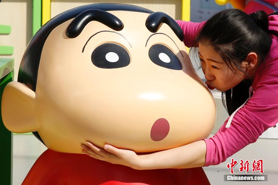 4月22日，游客與蠟筆小新合影?！跋灩P小新25周年紀(jì)念特展”日前在北京開(kāi)展，吸引了不少市民游客。