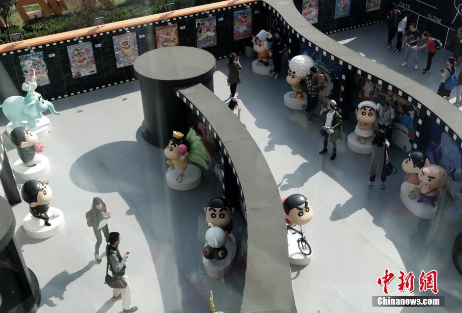 4月22日，游客與蠟筆小新合影?！跋灩P小新25周年紀(jì)念特展”日前在北京開(kāi)展，吸引了不少市民游客。