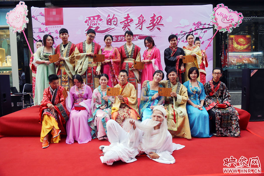 現(xiàn)場8對兒年輕男女舉起“賣身契”集體拍照。