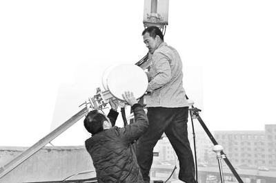 執(zhí)法人員在拆除非法無線電設(shè)備 執(zhí)法人員在拆除非法無線電設(shè)備