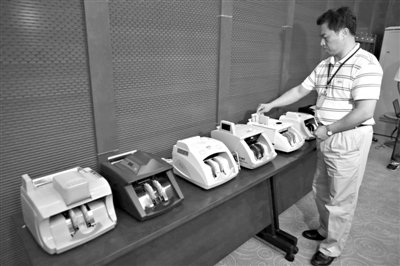 昨日，央行工作人員用各種驗(yàn)鈔機(jī)對(duì)C1F9假幣進(jìn)行測試，機(jī)器均能及時(shí)作出異常報(bào)警反應(yīng)。新京報(bào)記者 浦