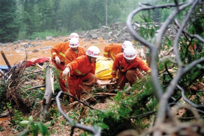昨日，消防隊員在四川省都江堰市中興鎮(zhèn)三溪村滑坡現(xiàn)場運送遇難者遺體。新華社記者 薛玉斌 攝