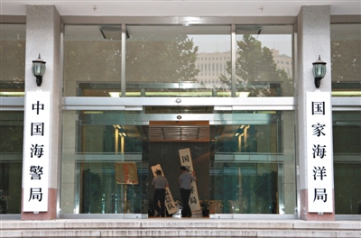 昨日，中國(guó)海警局掛牌成立。原國(guó)家海洋局和中國(guó)海監(jiān)總隊(duì)的牌匾被摘下，國(guó)家海洋局和中國(guó)海警局的新牌匾換上。黃冉 攝