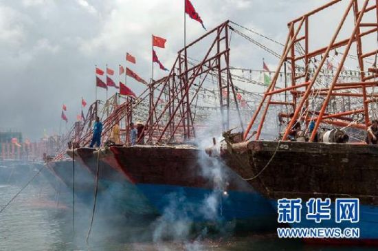 2013年8月1日 南海開漁日 臨高迎新港 8月1日，海南省臨高縣漁民在船上鳴放鞭炮慶祝武蓮港開港。