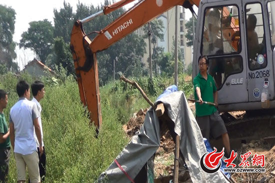 陳寶成手持自制刀斧守在挖掘機旁阻止便衣民警靠前。駕駛室內，張朋珂正向受害人郭曉剛身上澆汽油。（視頻截圖）