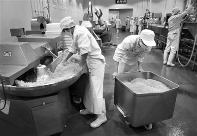 昨日，位于順義李遂開發(fā)區(qū)的慶豐包子鋪配送中心生產(chǎn)車間，工人們正在斬拌胡蘿卜餡料。