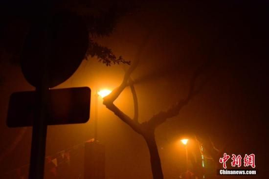 1月31日凌晨，市民行走在煙霧繚繞的南京街頭。當(dāng)天是農(nóng)歷馬年正月初一，南京有限開禁燃放煙花爆竹正逢下霧天，空氣的不流通致使煙花爆竹燃燒后產(chǎn)生的顆粒物不能及時散開，造成整座城市煙霧繚繞。據(jù)當(dāng)?shù)丨h(huán)保部門發(fā)布的信息顯示，空氣質(zhì)量屬重度污染。中新社發(fā) 泱波 攝