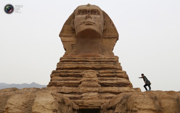 石家莊郊外，一名男子與山寨版獅身人面像合影留念。