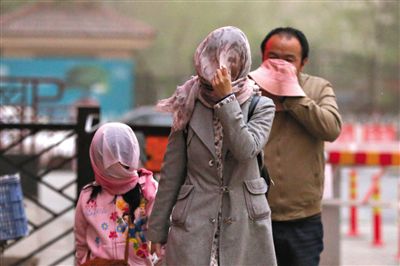 昨日下午，朝陽(yáng)區(qū)豆各莊，行人將紗巾裹在頭上防沙塵。