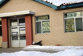 伊春市帶嶺區(qū)一排破舊的平房，房間窗戶上貼滿了“我告饒了”的字樣。