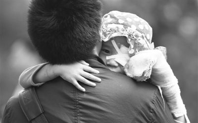 昨日，北京同仁醫(yī)院，被砍傷的彤彤趴在舅舅的肩上。他們剛剛掛完號(hào)，正準(zhǔn)備回旅館。新京報(bào)記者 尹亞飛 攝