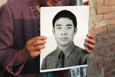 5月19日，朝陽北路，母親捧著張東文的遺像。新京報(bào)記者 侯少卿 攝