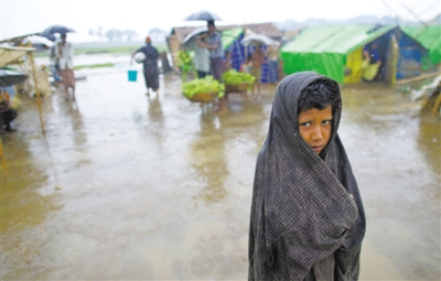 5月14日，緬甸若開邦實(shí)兌難民營(yíng)，羅興亞族難民在雨中行走。熱帶風(fēng)暴“馬哈森”即將登陸緬甸，這里的難民開始乘船撤離。