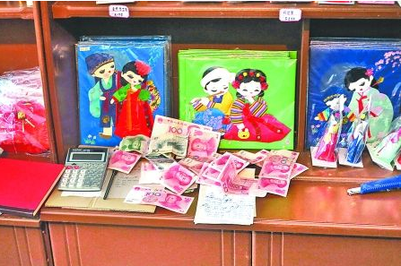 　　2012年6月21日，在朝鮮羅先特別市的一家商店里，柜臺上散落著一些人民幣。在朝鮮，人民幣比本國