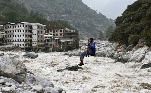 一名印度男子靠繩索渡河。