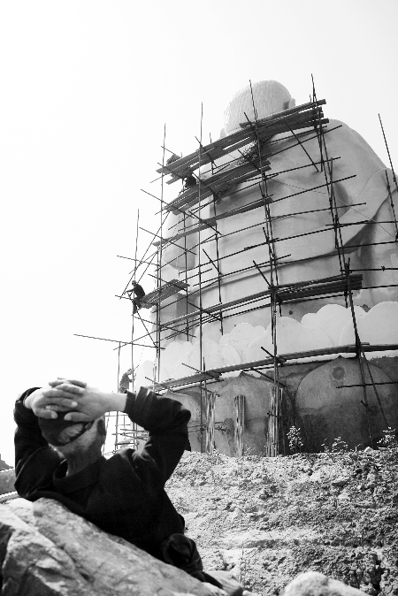 今年4月26日，工作人員將帆布蓋在“佛像”頭像上