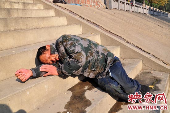 這名男子的衣服以及褲子全濕透了，水從衣褲里流出來，嘴里散發(fā)著濃烈的酒氣。