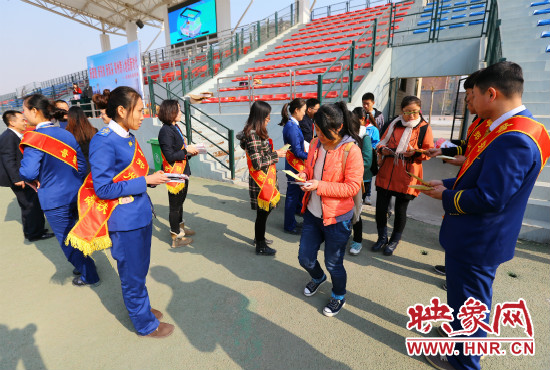 活動(dòng)現(xiàn)場工作人員給同學(xué)們發(fā)放宣傳冊(cè)、環(huán)保袋。