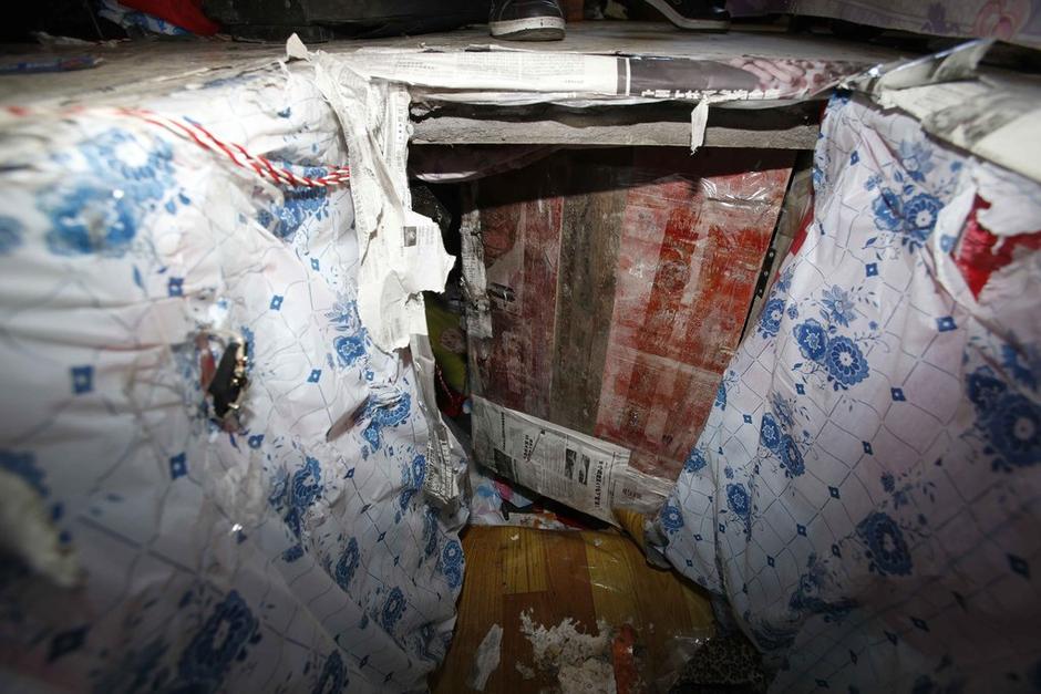 陳小龍在出租屋外，自行又圍起一堵圍墻，安裝了一個門。圍墻上都是豎起的鐵釘，外面堆著土，鄰居猜是從地底挖出來的。洞口就在床邊，0.5米見方，深約1.5米。洞口表面一塊紙板掩蓋，打開紙板跳入洞底，是一扇小木門，木門外有插銷，可以從外面鎖上。