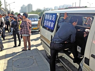 昨日，朝陽區(qū)看守所門前有人排隊。大門外還停有多輛寫有“律師會見”字樣的車。