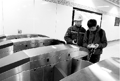 昨天上午，體育中心站，工作人員正在對進出站閘機進行調(diào)試。