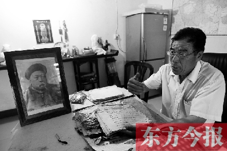 　魏樹紹手拿《物權(quán)法講義》手稿，在講訴先祖書寫“物權(quán)法”的歷史（相框里就是魏聯(lián)奎）