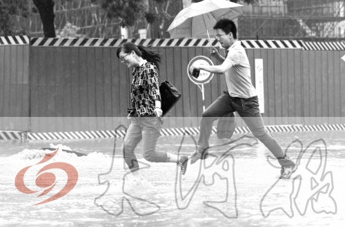 鄭州經(jīng)三路與北環(huán)交叉口處，積水較深，行人們不得不“練輕功”。 記者 白周峰 攝影