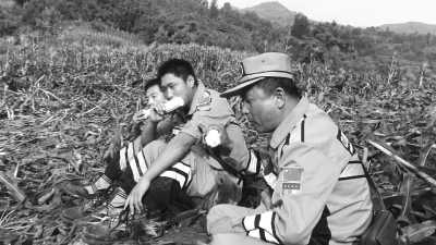 饑餓難忍，中國(guó)緊急救援河南基地的救援隊(duì)員在已毀的玉米地里撿拾生玉米吃。