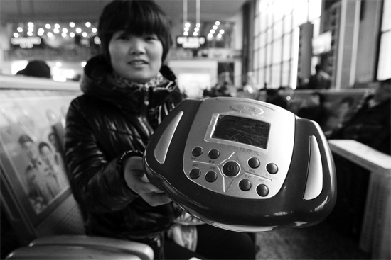 火車站候車室，李女士向記者展示她準備孝敬父母的按摩儀