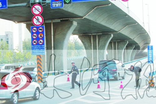 交警在東風(fēng)路從北向南上橋口處擺上反光錐，間歇放行