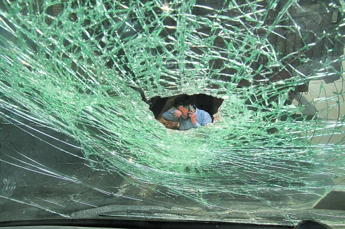 白師傅看著被砸壞的車輛焦急地打電話求助 白師傅看著被砸壞的車輛焦急地打電話求助