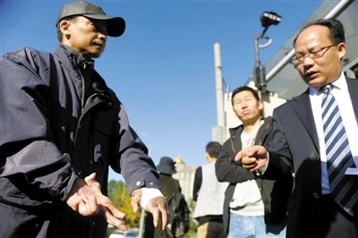 常林鋒在法院外展示雙手，他稱被燙傷的手因刑訊逼供且未得到及時救治