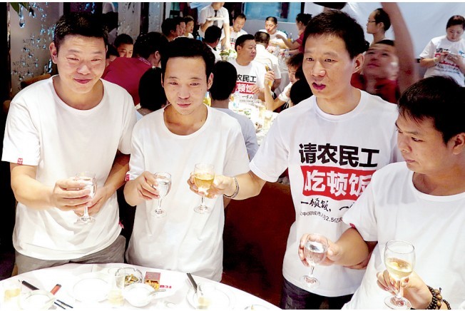 活動發(fā)起人張楠（右二）給農(nóng)民工敬酒。