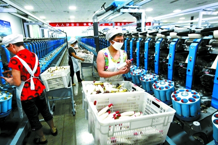 6月6日，舞鋼市鑫海紡織有限公司員工正在新建成的紡紗車間生產(chǎn)。