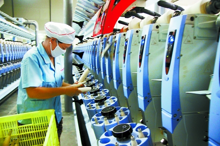7月3日，在鄧州市永泰棉紡有限公司電腦控制全自動紡紗車間，紡織工人正在生產(chǎn)棉紗。